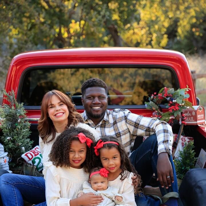 A family of five photographed in the decorated bed of the red 1972 Ford F-100 during a holiday mini session.